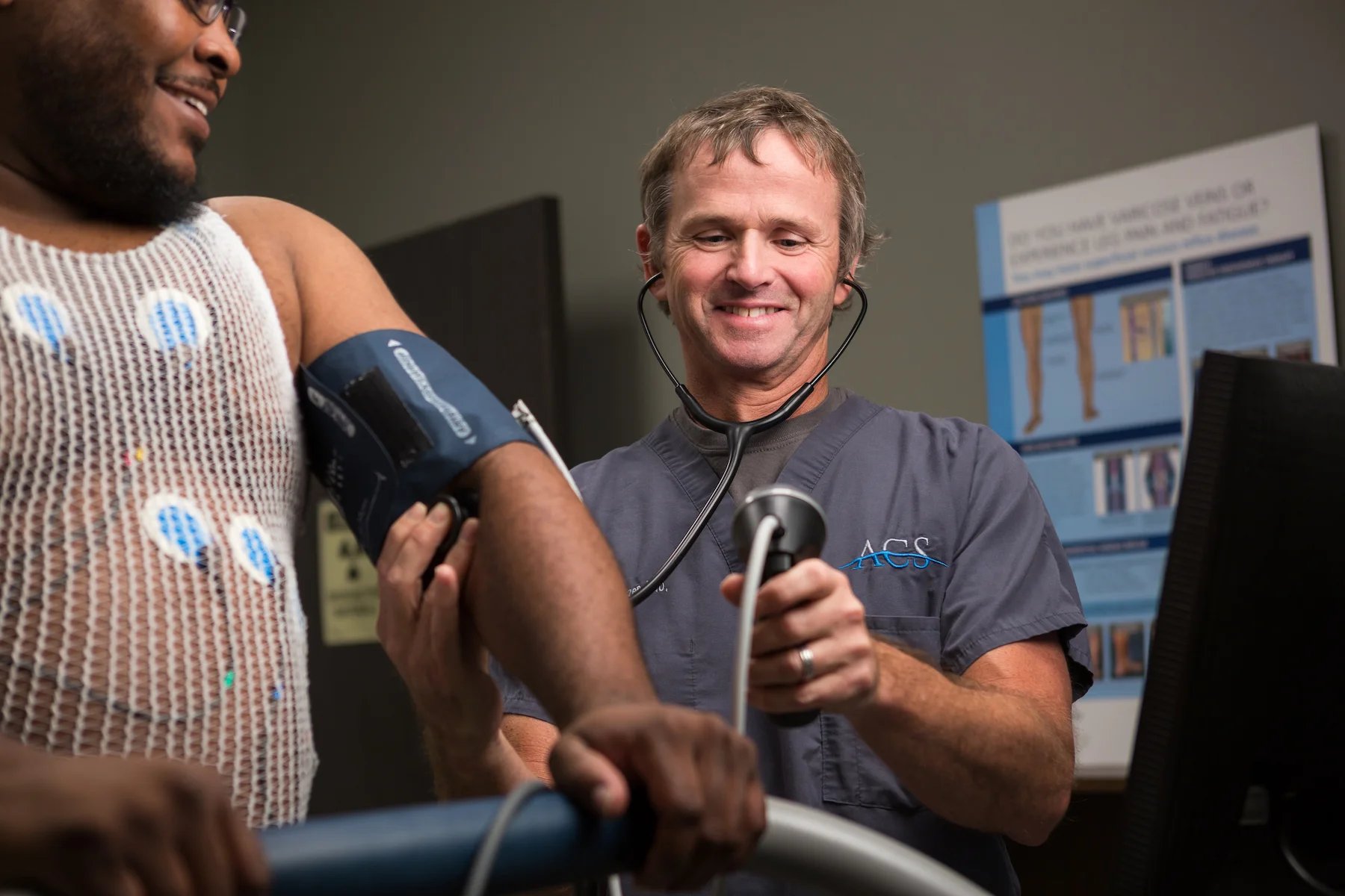 A healthcare professional takes a patient's blood pressure during a medical exam.